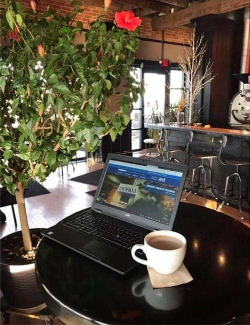 a picture of a laptop 和 a cup of coffee at a local coffee shop